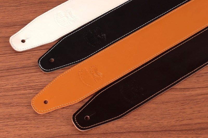Four Soldier cowhide guitar straps in white, black, tan and dark brown
